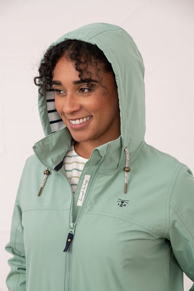 Lighthouse Beachcomber Jacket in Basil- Waterproof and Breathable Polyester Rain Coat with striped lined hood and pockets, focus on hood details on model