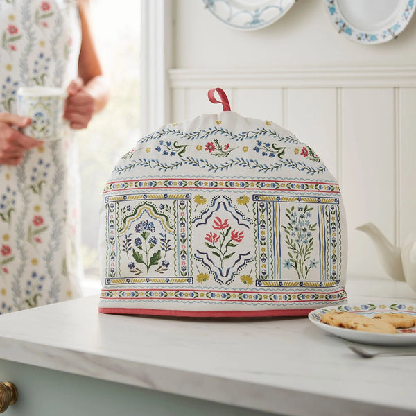 Decorative tea cozy with floral pattern on a kitchen counter.