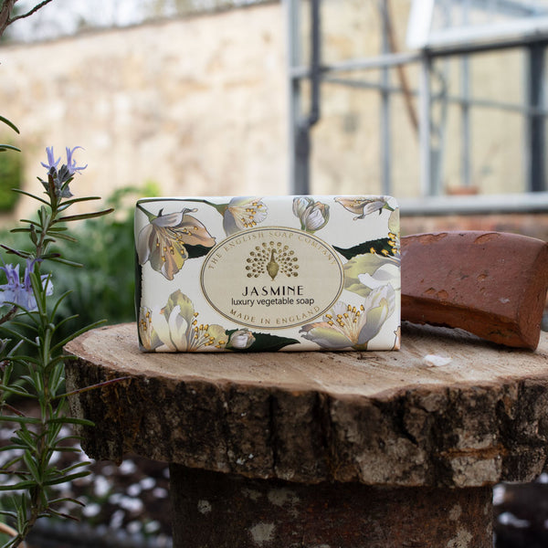 Bar of soap with floral design wrapper on a wooden surface outdoors