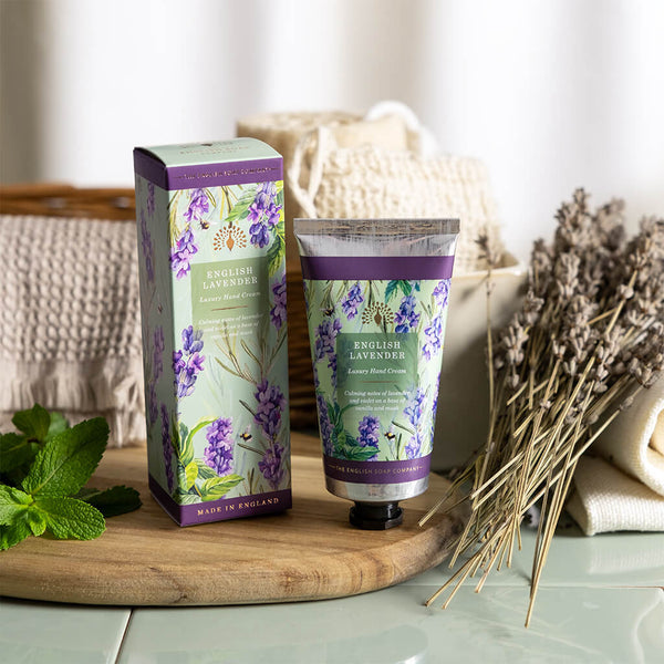 Hand cream and packaging with lavender design on a wooden board.
