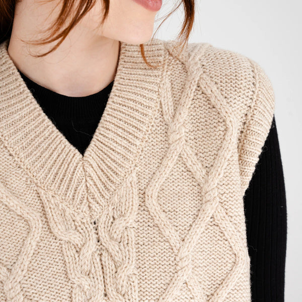 Oversized Aran Cable Vest in Parsnip - close up view of cable knit detail, on model
