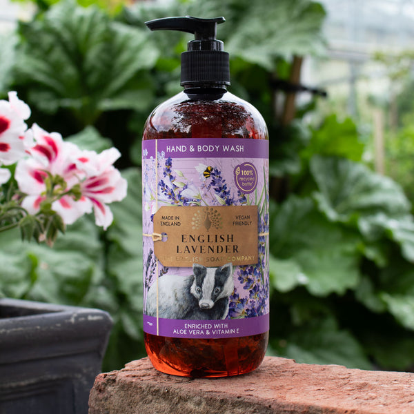 Hand and body wash bottle labeled 'English Lavender' on a stone surface with plants in the background