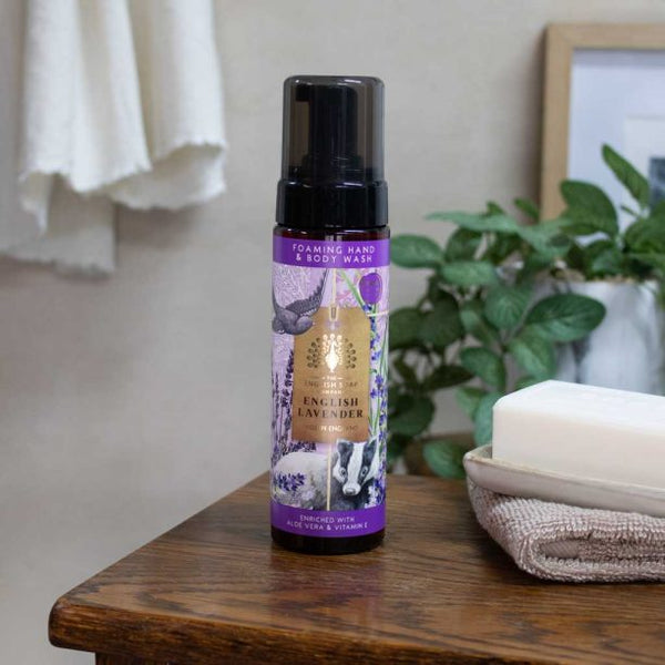 Foaming Hand and Body Wash Anniversary English Lavender bottle sitting on wooden table that appears to be in a bathroom.