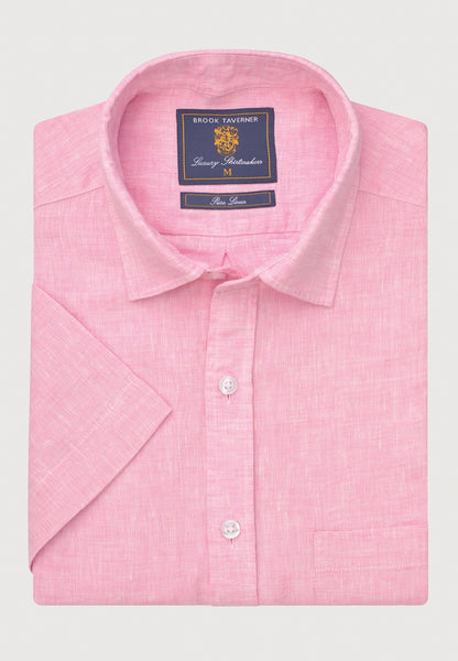 A folded light pink short-sleeve shirt with a textured linen weave, featuring a pointed collar and button down shirt.