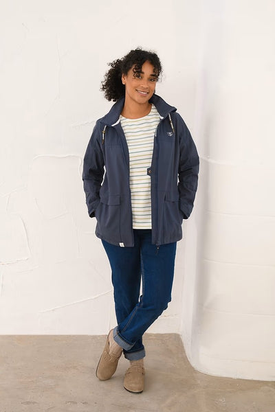 Person wearing a blue Lighthouse Beachcomber jacket and striped shirt against a white background