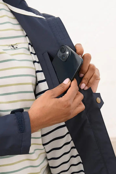 Lighthouse Beachcomber Jacket in Navy- Waterproof and Breathable Polyester Rain Coat with striped lined hood and pockets, close up on lining and pocket details, on model