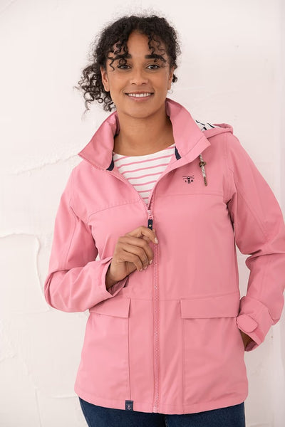 Person wearing a pink Lighthouse Beachcomber raincoat with a white background