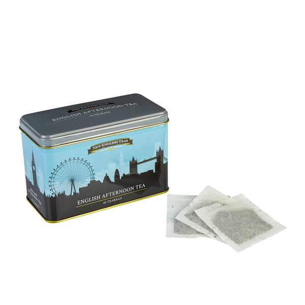 Tin box of English Afternoon Tea with London skyline design and three teabags sitting on white table.