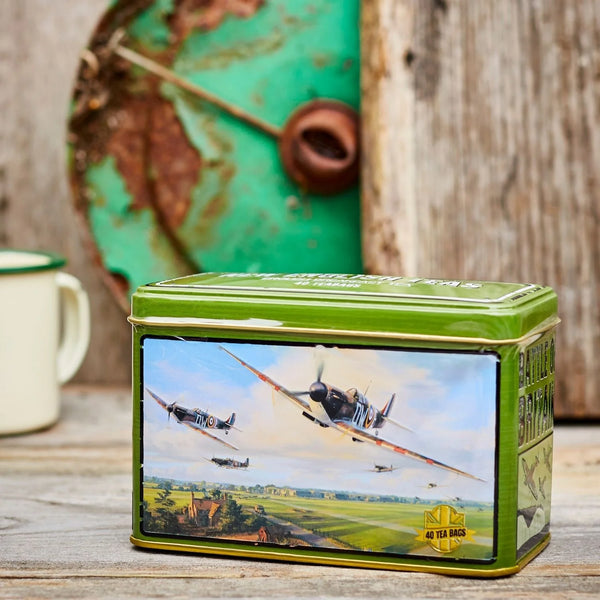 Tea tin with vintage spitfire airplane design and 'New English Tea' branding sitting on wooden table